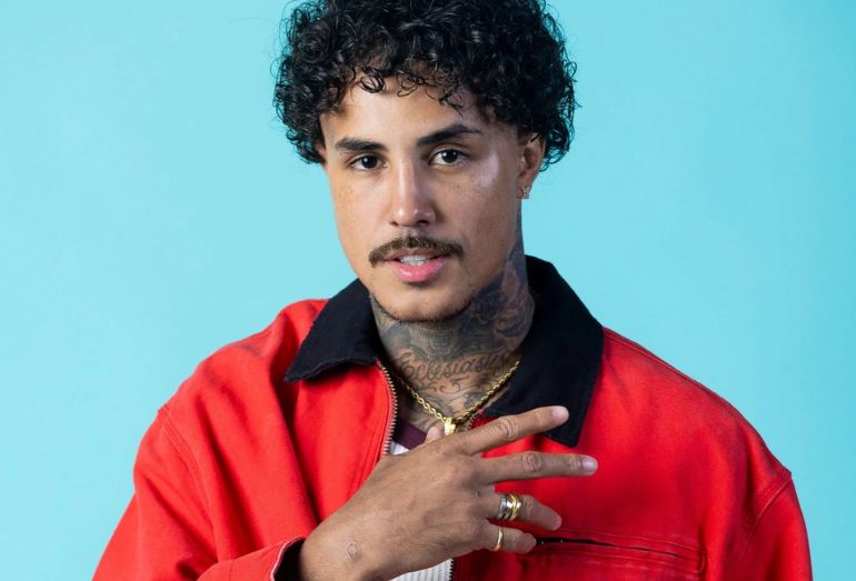 Retrato de estúdio do cantor MC Livinho, em foto de divulgação, olhando para a câmera com um fundo neutro.