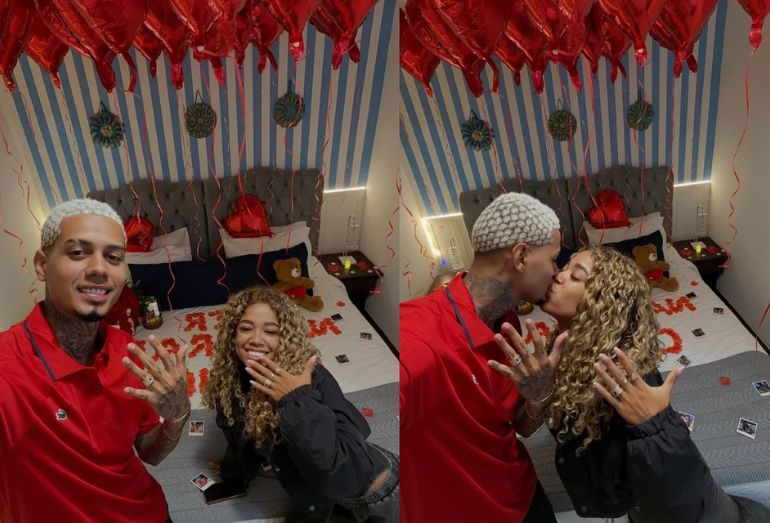 ivi Noronha e o influenciador Da Fúria sorrindo em um quarto decorado com balões vermelhos e flores.