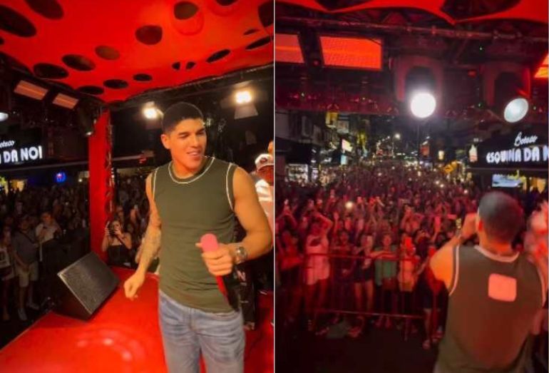 Foto do cantor Zé Vaqueiro no palco montado na Rocinha, interagindo com o público durante a noite; ao fundo, é possível ver a multidão e luzes do evento local.