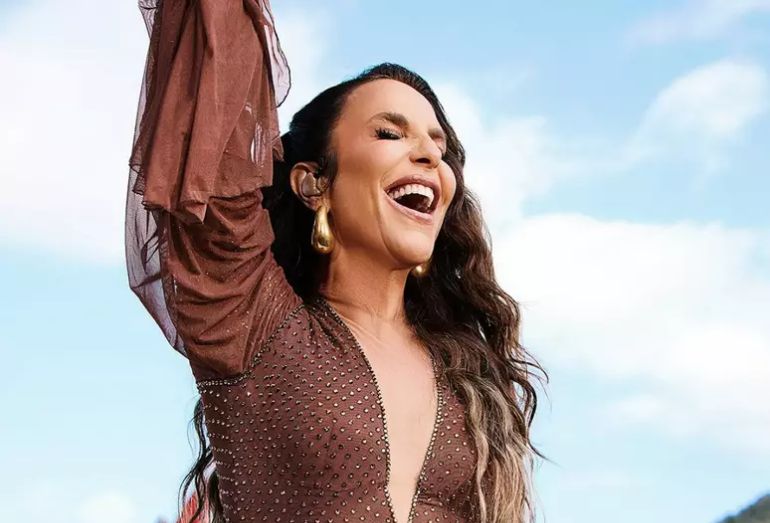 Foto da cantora Ivete Sangalo sorridente no palco, usando figurino vibrante, em um cenário que remete a uma roda de samba estilizada.