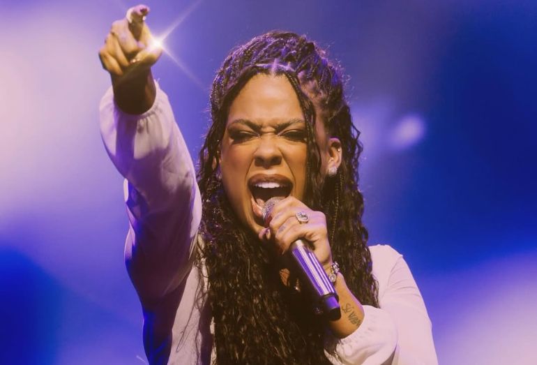 Cantora Marvvila no palco durante apresentação, segurando o microfone.