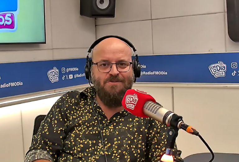 O comediante Paulinho Serra falando ao microfone dentro do estúdio da rádio FM O Dia.