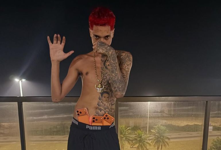 Foto do rapper Oruam usando vários cordões de ouro grossos no pescoço e sem camisa,.